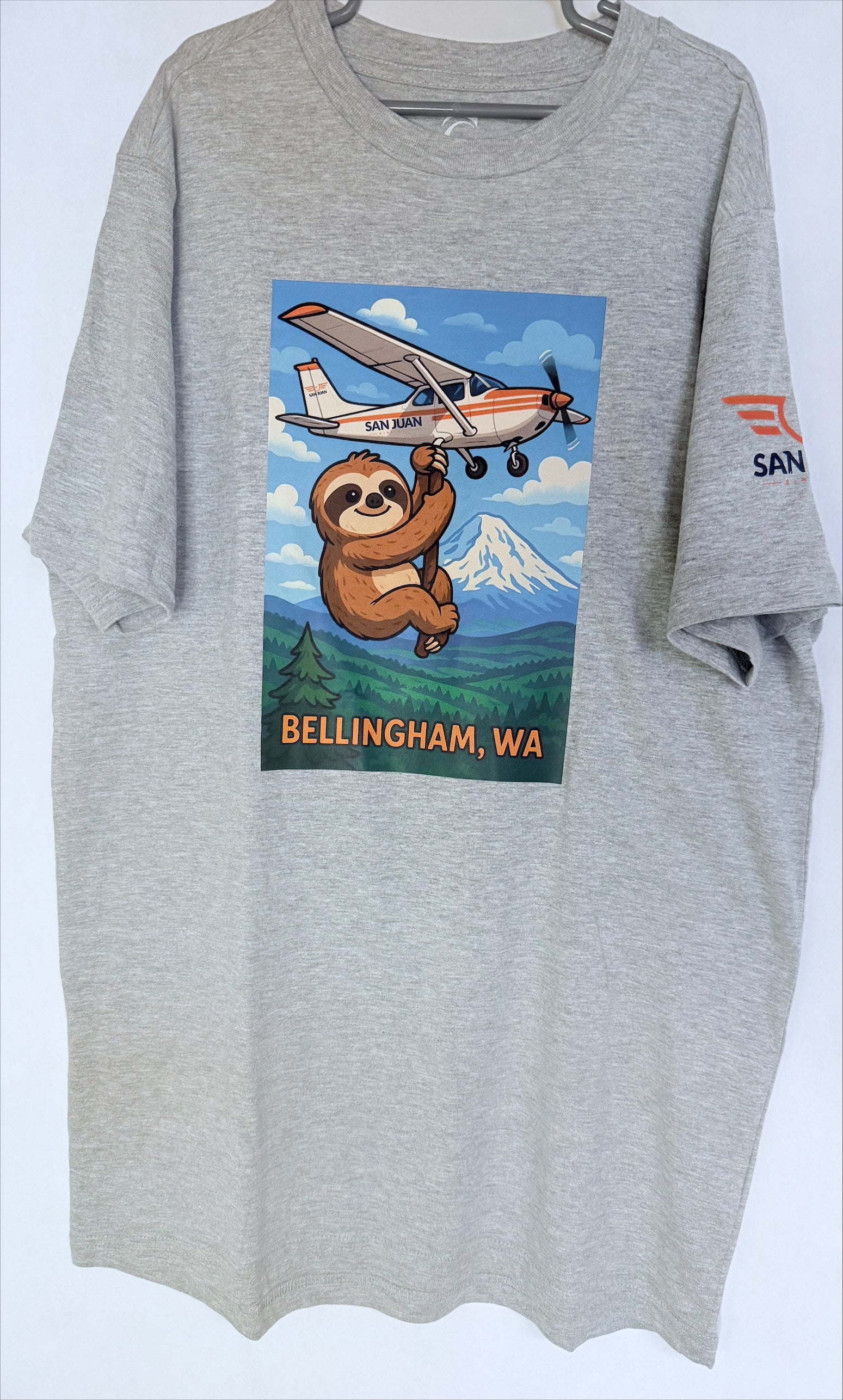 Gray t-shirt with a sloth holding a plane graphic and 'Bellingham, WA' text on a white background